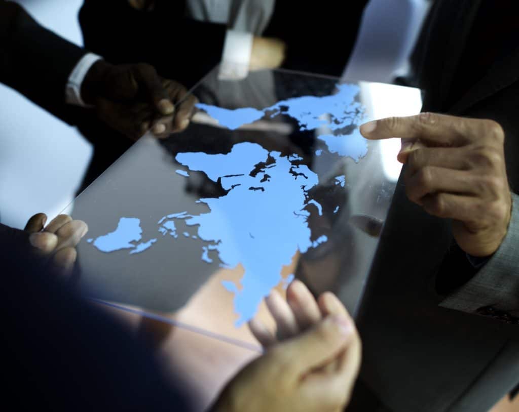 Foreign trade business team planning customs clearance solutions and working with a world map on a transparent board.